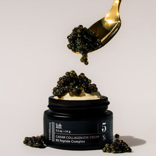 A jar of Savor Beauty Caviar Collagen Eye Cream with 9% Peptide Complex is shown with a spoon lifting some cream, surrounded by caviar pieces.