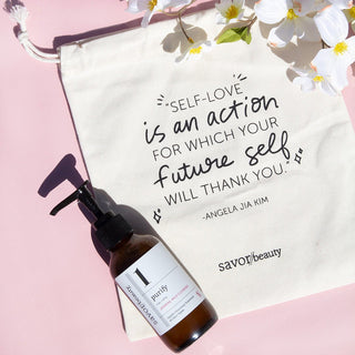 Jasmine Milk Cleanser laying on top of makeup bag