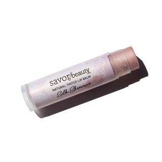 Silk Shimmer tinted lip balm laying against white background.