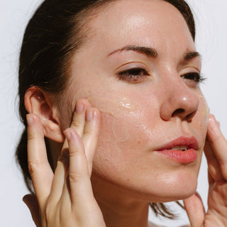 Woman applying Pearl Cleansing Cream to face.