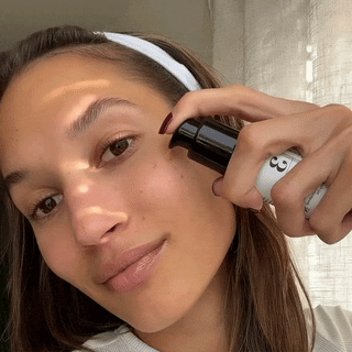 GIF of a young woman applying a pump of the Raspberry Seed Serum and massaging into here skin