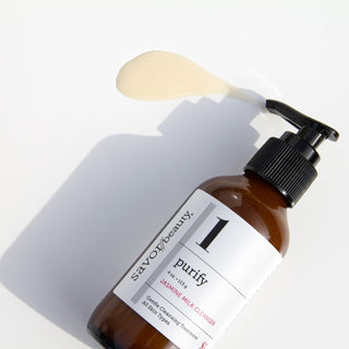 Bottle of Jasmine Milk Cleanser laying down with product swatch next to it