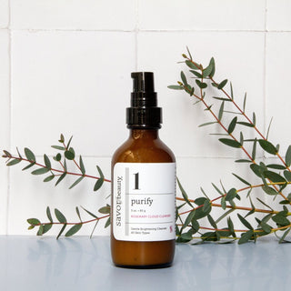 Rosemary Cleanser bottle with fresh rosemary in the background