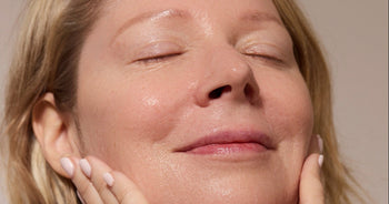 Woman with her eyes closed, washing her face