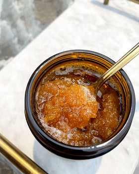 honey sugar scrub in a jar on a counter