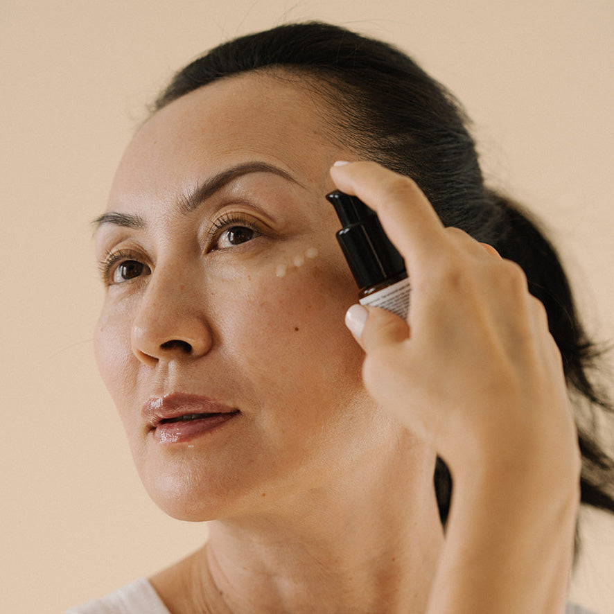 Woman with a face cream on her cheek