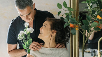 women and man kissing at their wedding in a park