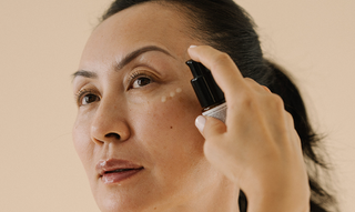 woman applying serum to her face