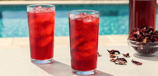 hisbiscus tea and flower petals next to a pool