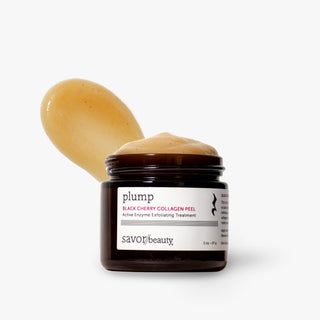 A jar of Savor Beauty Plump Black Cherry Collagen Peel with a scoop of the peach-colored cream product resting behind it, set against a clean white background.