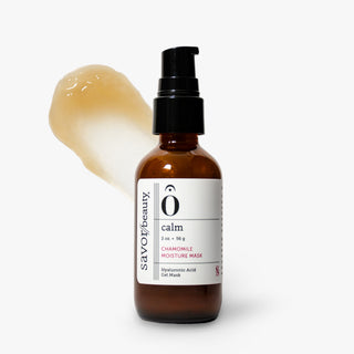An amber glass pump bottle labeled Savor Beauty 'calm' Chamomile Moisture Mask, shown on a light gray background with a smear of the pale yellow mask behind it.
