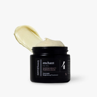 A black jar of Savor Beauty Enchant Sleeping Beauty Pumpkin Cream with a dollop of pale yellow cream visible on top, set against a clean white background.