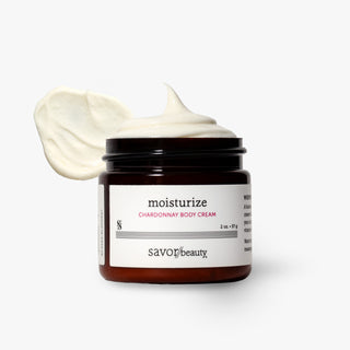 A jar of Savor Beauty Chardonnay Body Cream with a swirl of white cream displayed above the open jar, set against a clean white background.