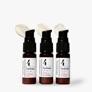 Three travel savor beauty face creams amber pump bottles labeled '4 hydrate' face cream, arranged side by side on a light gray background, with dollops of pale cream shown above each bottle.