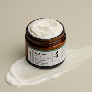 Jar of face cream labeled 'hydrate' on a beige background with swatch of cream underneath