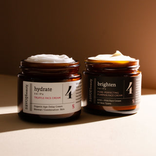 Two jars of skincare cream labeled 'hydrate' and 'brighten' on a neutral background