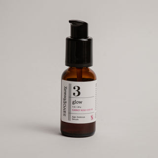 Skincare serum bottle labeled '3 Glow' on a gray background