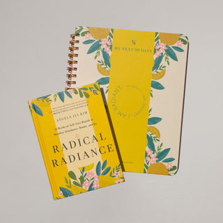 Yellow planner and book laying on a gray background