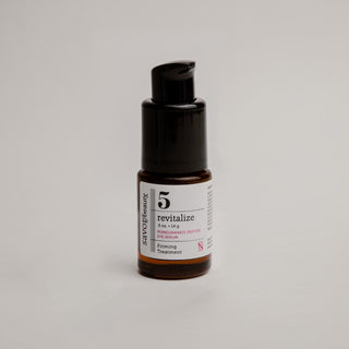 Skincare serum bottle labeled 'revitalize' on a gray background