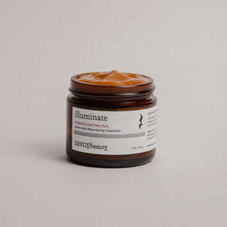 Jar of skincare product labeled 'illuminate' on a neutral background