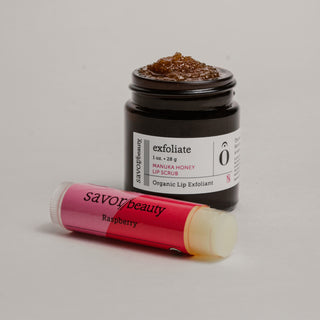 Jar of honey exfoliant and lip balm on a gray background