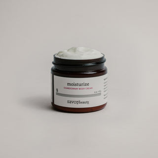 Jar of moisturizing cream with 'savor beauty' label on a neutral background