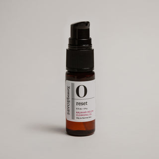 Travel size skincare bottle labeled 'reset' on a light gray background