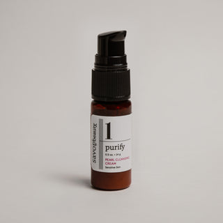 Skincare serum bottle labeled 'purify' on a gray background