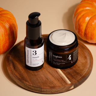 Skincare products on a wooden board with pumpkins in the background
