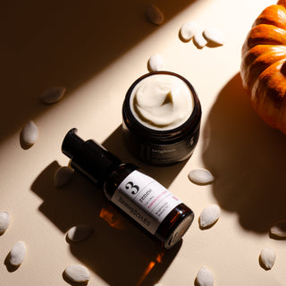 Cosmetic bottles with a pumpkin on a textured surface