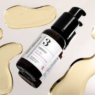 Skincare serum bottle with dropper on a light background with gold oil patches