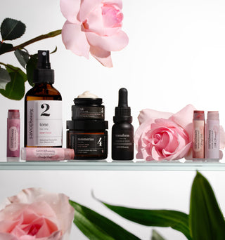 Skincare products with pink roses on a white background