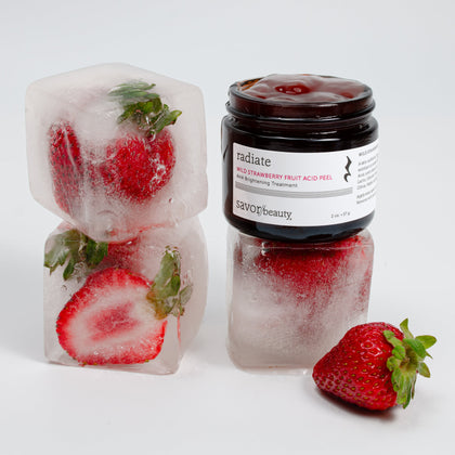 Jar of strawberry peel on top of ice cubes with fresh strawberries inside