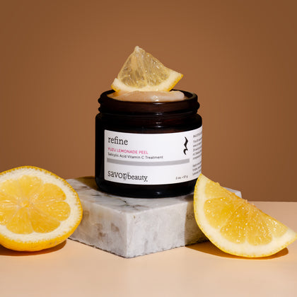 Jar of Yuzu Lemonade Peel with lemon slices on a brown background