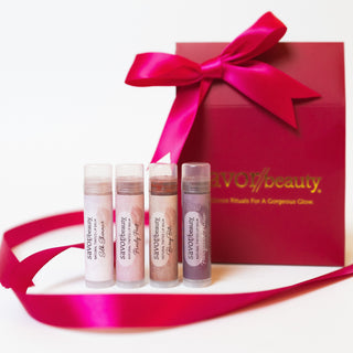 Set of lip tints with a red gift box and pink ribbon on a white background