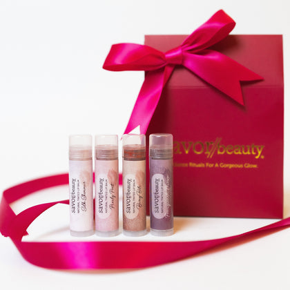 Set of lip tints with a red gift box and pink ribbon on a white background