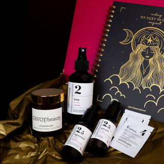 Skincare products and a notebook with a decorative cover on a gold surface.