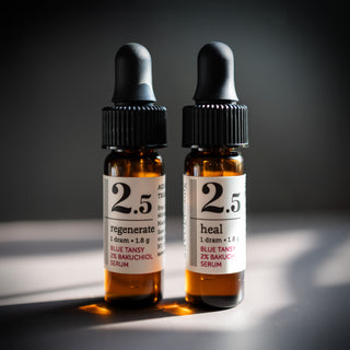 two glass dropper bottles of both heal and regenerate on a moody background 