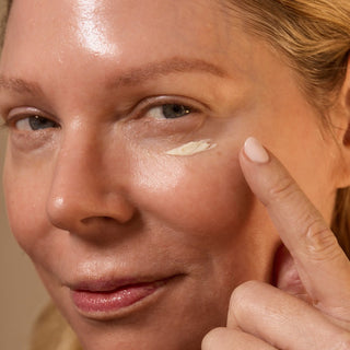 Woman applying cream to her face with a finger