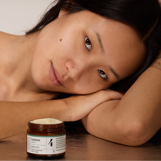 Woman lying down with a jar of cream