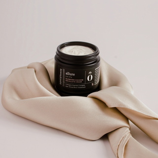 Black jar of neck cream wrapped in a champagne colored silk scarf
