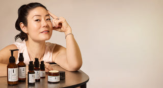 Founder, Angela Jia Kim with skincare products on a neutral background