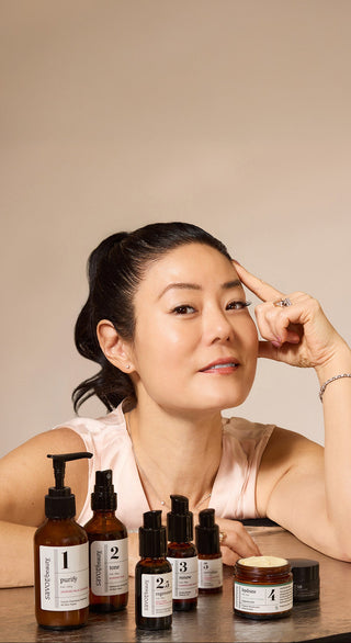 Founder, Angela Jia Kim with skincare products on a neutral background