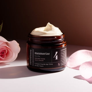 Cosmetic jar labeled 'mesmerize' with cream on a white surface with pink roses.