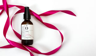 Bottle of chamomile mask with a pink ribbon on a white background